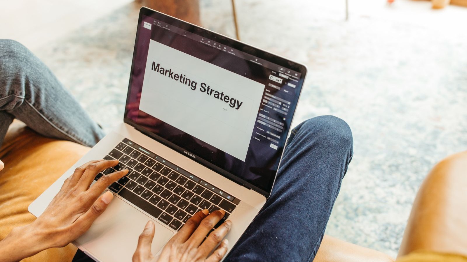 Osoba pracuje na laptopie nad strategią marketingową w domowym biurze