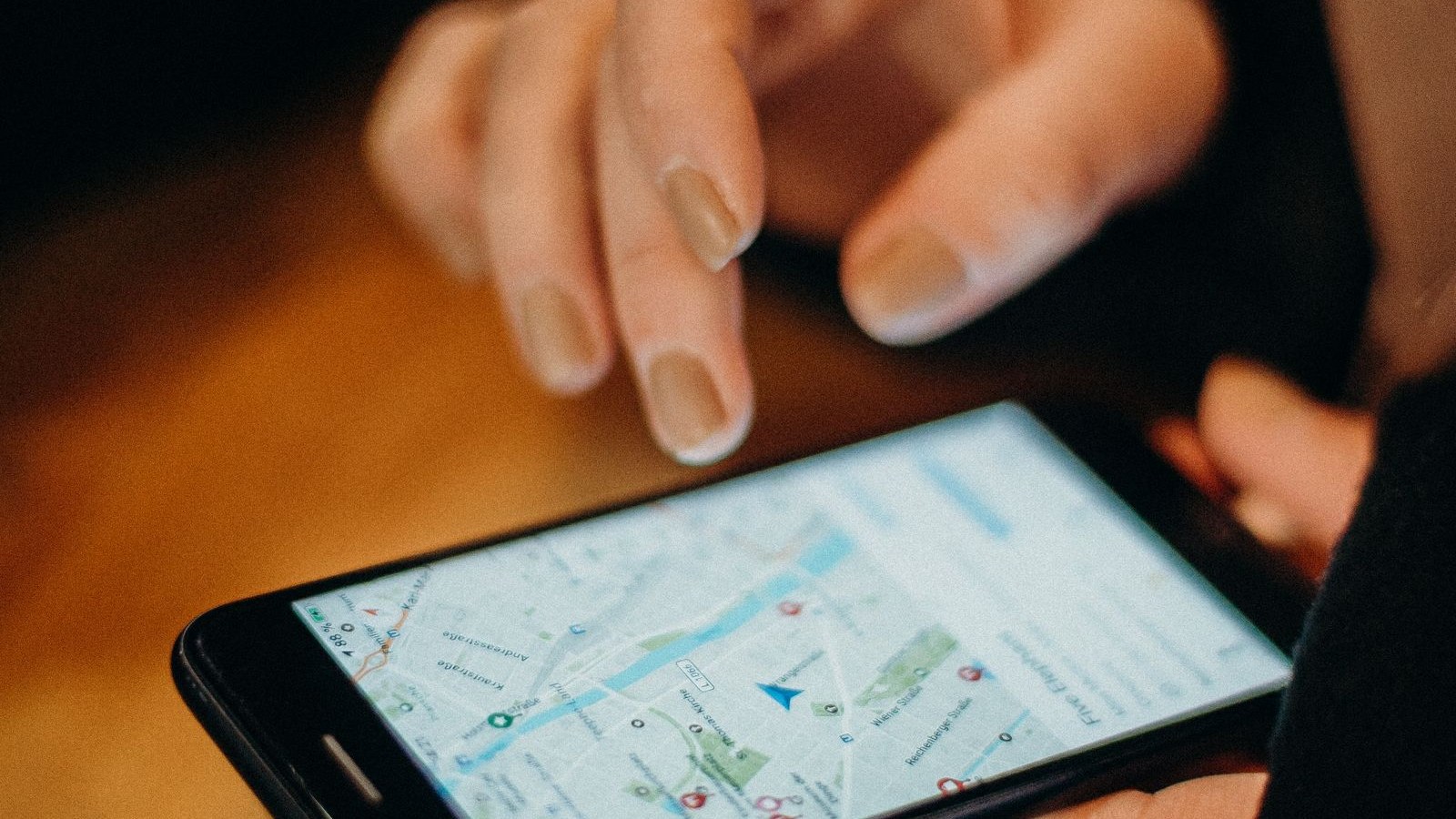 Osoba wyszukuje salon kosmetyczny w telefonie na mapie